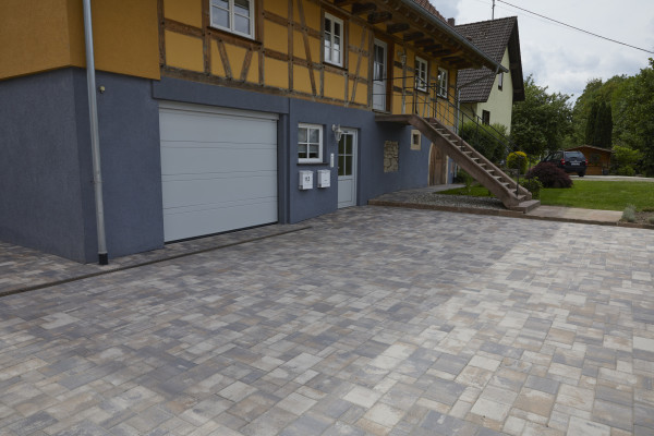 Trisano Pflasterstein vor einem Hauseingang mit Garage und Garten